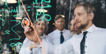 Four people on a glass whitboard