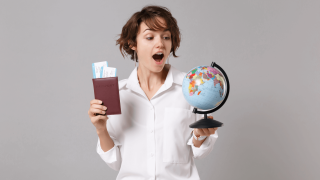 Young Woman holding passport, airtravel tickets and a globe looking excited 