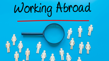 Visual with magnifying glass, people and inscription working abroad