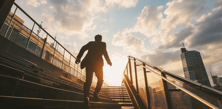 Man in business dress walking up outsides stairs in the sun